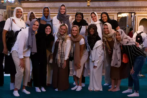 Wisconsin volleyball photo with all student-athletes wearing scarves over their heads during the Badgers' 2023 European Tour