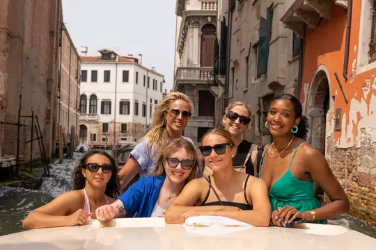 Wisconsin volleyball teammates together on a canal cruise in Venice, Italy during the Badgers' 2023 European Tour