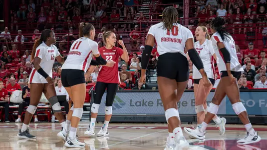 Team celebrates on the court after winning a point