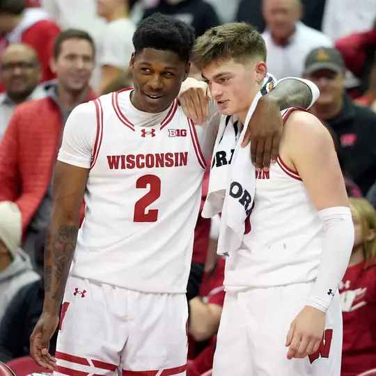 AJ Storr and Chucky Hepburn embrace on the bench during a game