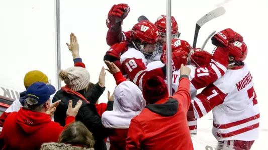The Wisconsin men's hockey team celebrates scoring a goal against Alaska Anchorage in front of fans at the Kohl Center