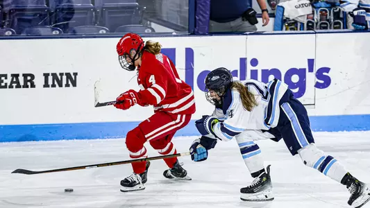 Caroline Harvey skates away from a Maine defender
