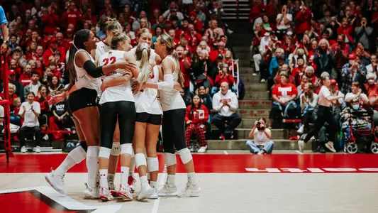 Team celebrates after winning a point in match vs Iowa