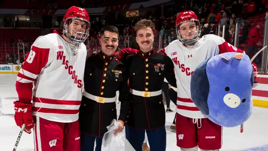 Owen Lindmark and Jack Horbach pose with Marines at the 2023 UW Teddy Toss