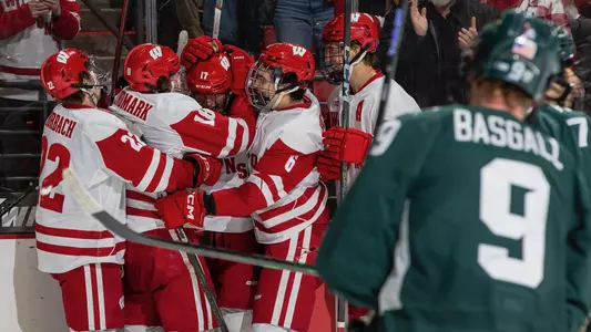 The Wisconsin men's hockey team celebrates scoring a goal against Michigan State