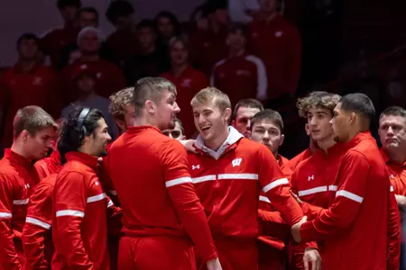 Shane Liegel is surrounded by teammates prior to his first wrestling dual match as a Badger