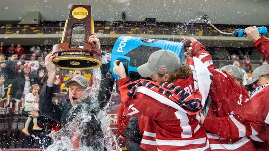 Britta Curl dumps a bucket of water onto Coach Mark Johnson after winning the 2023 NCAA Championship game
