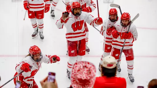 Wisconsin women's hockey celebrates a goal with the crowd