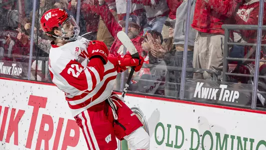 Jack Horbach tugs on his jersey to show off the Wisconsin logo