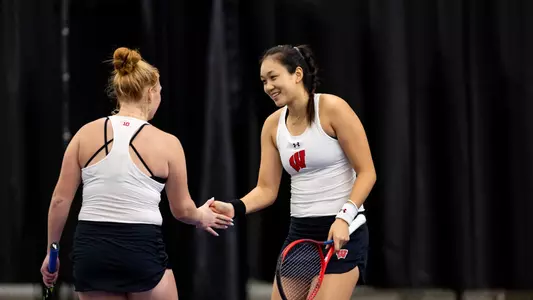 Xinyu Cai and Ellison Reynoldson high-five after a point
