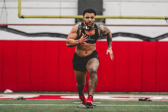 Chez Mellusi sprints with chains during winter speed training at the UW McClain Center indoor football field.