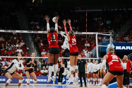 Devyn Robinson and Charlie Fuerbringer block the ball in match at Louisville