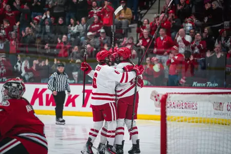 The Wisconsin women's hockey team celebrates on the ice after a goal in the game vs St. Cloud State