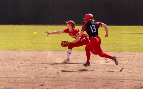 Hannah Conger flips the ball for the putout against NIU