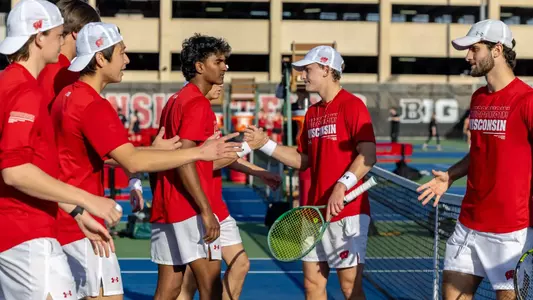 Wisconsin men's tennis team congratulate each other after doubles play