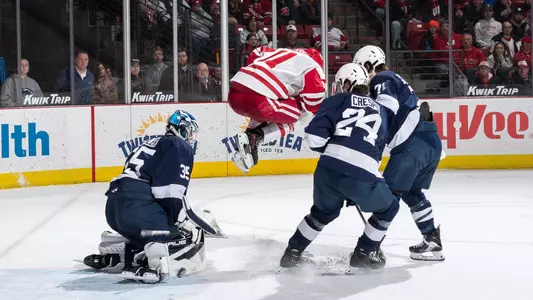 Simon Tassy leaps over a puck versus Penn State.