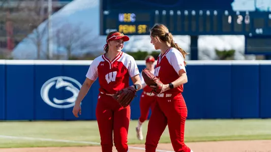Alivia Bark and Shelby Jacobson meet after an inning versus Penn State.
