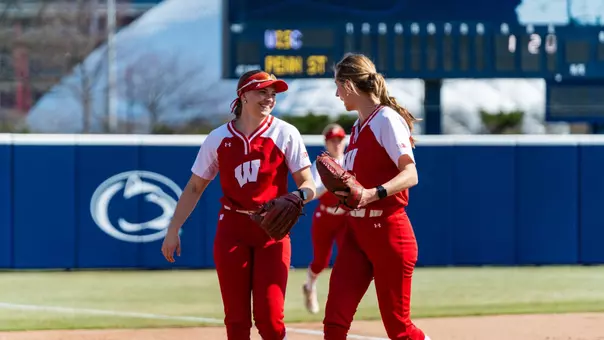 Alivia Bark and Shelby Jacobson meet after an inning versus Penn State.