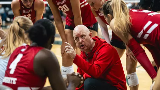 Kelly Sheffield talks in a huddle against Green Bay.