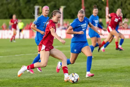 jane Rogers moving with the ball against two defenders - Wisconsin Women's Soccer vs BYU