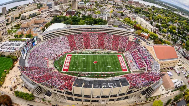 A sea of red- and white-attired fans fill Camp Randall Stadium at the University of Wisconsin–Madison as the Wisconsin Badgers play the Iowa Hawkeyes during a football game on Oct. 14, 2023. The aerial photograph made with a fisheye lens was taken from a helicopter looking east toward the isthmus during autumn. Wisconsin lost to Iowa, 15-6, before a crowd of 76,205 people. (Photo by Jeff Miller / UW–Madison)