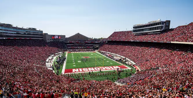 Seen in a sea of red and white, Wisconsin Badgers football fans cheer as Wisconsin plays the Purdue Boilermakers in a football game at Camp Randall Stadium at the University of Wisconsin–Madison on Oct. 5, 2024. Wisconsin won, 52-6. (Photo by Jeff Miller / UW–Madison)