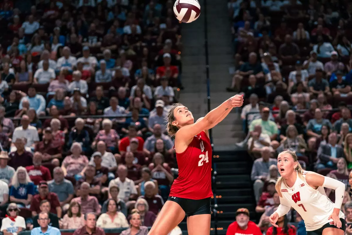 Wisconsin setter Charlie Fuerbringer (#24) passes the ball overhead while teammate Kristen Simon (#7) looks on during match play at Texas A&M.