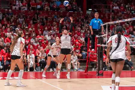 Kristen Simon jump-sets the ball as her Wisconsin teammates prepare to attack against Oregon.