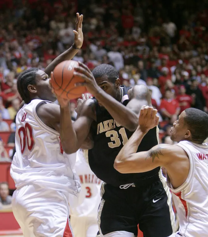 Eric Williams drives between New Mexico's Bambale Osby, left, and Mark Walters. (AP Photo/Jake Schoellkopf)