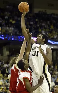 Eric Williams shoots over Richmond players Jamaal Scott and Drew Crank during the first half.