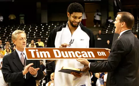 Winston-Salem Mayor Allen Joines, left, and Wake Forest athletic director Ron Wellman present San Antonio Spurs' Tim Duncan a street sign in his honor.