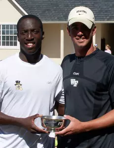 Todd Paul and assistant coach Andrew Simpson accept the consolation bracket championship trophy after Paul's Sunday victory