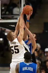 Chad Mohn has his shot blocked by Kyle Visser in the first half.(AP Photo/Lynn Hey)