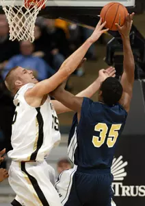 Kyle Visser blocks the shot of Charleston Southern's VJ Falls.