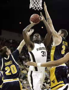 Eric Williams shoots between West Virginia's Mike Gansey and Kevin Pittsnogle. (AP Photo)