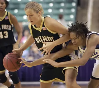 Monique Currie, right, knocks the ball from Wake Forest's Liz Strunk.