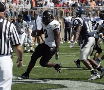 Wake Forest's Micah Andrews runs the ball in for a touchdown as Connecticut's Marvin Taylor (10) watches during the first half of a college football game in East Hartford, Conn., Saturday, Sept. 16, 2006. (AP Photo/Bob Child)