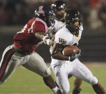 Wake Forest's Kenneth Moore (21) is tackled by Mississippi's Quentin Taylor (10) during a football game in Oxford, Miss. on Saturday, Sept. 23, 2006. (AP Photo/Oxford Eagle, Bruce Newman)