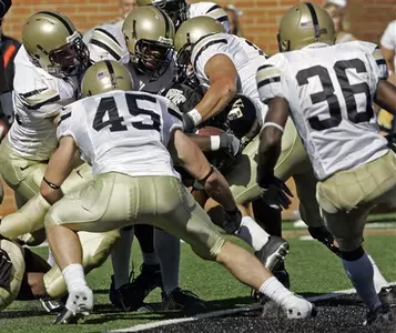 Wake Forest's Josh Adams, center, pushes over the goal line for a touchdown.