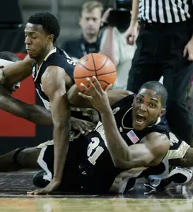 Jamie Skeen (31) scrambles on the floor with a loose ball next to teammate Ishmael Smith, left, during the first half. (AP Photo/Michael Dwyer)