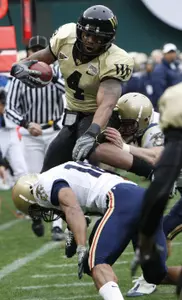 D.J. Boldin leaps over Navy's Rashawn King and Ross Pospisil. (AP)