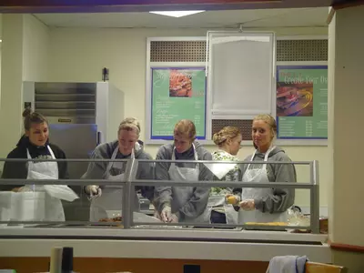 Lauren McIntyre and Kate Rodriguez prepare meals for the needy.