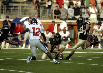 Sam Swank, right, gets ready to kick the game-winning field goal as teammate Ryan McManus holds the ball and Mississippi cornerback Dustin Mouzon (12) rushes the play. Wake Forest won 30-28. (AP Photo/Nell Redmond)