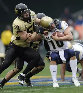 Navy quarterback Kaipo-Noa Kaheaku-Enhada is tackled by defensive tackle John Russell. (AP)