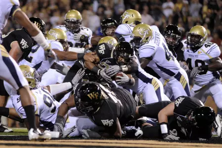 Wake Forest running back Brandon Pendergrass breaks through the attempted tackles of the Georgia Tech defense . (AP Photo/Winston-Salem Journal, Bruce Chapman)