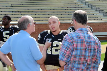 Skylar Jones talks with a couple writers at Media Day.