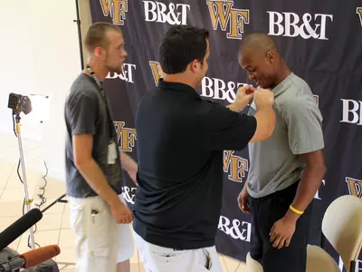 Chris Givens gets mic'ed up for an interview with the local TV stations.