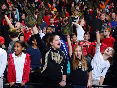 A young fan holding cheering on the Demon Deacons.