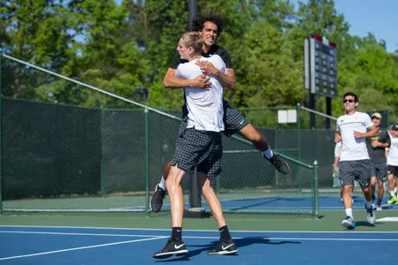 Skander Mansouri and Christian Seraphim celebrate Seraphim's win at No. 5 singles that tied the match at three.