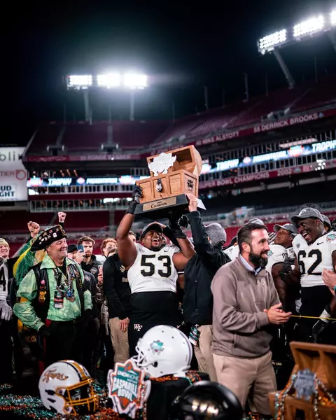 Photo of Je'Vionte' Nash holding up the Gasparilla Bowl trophy